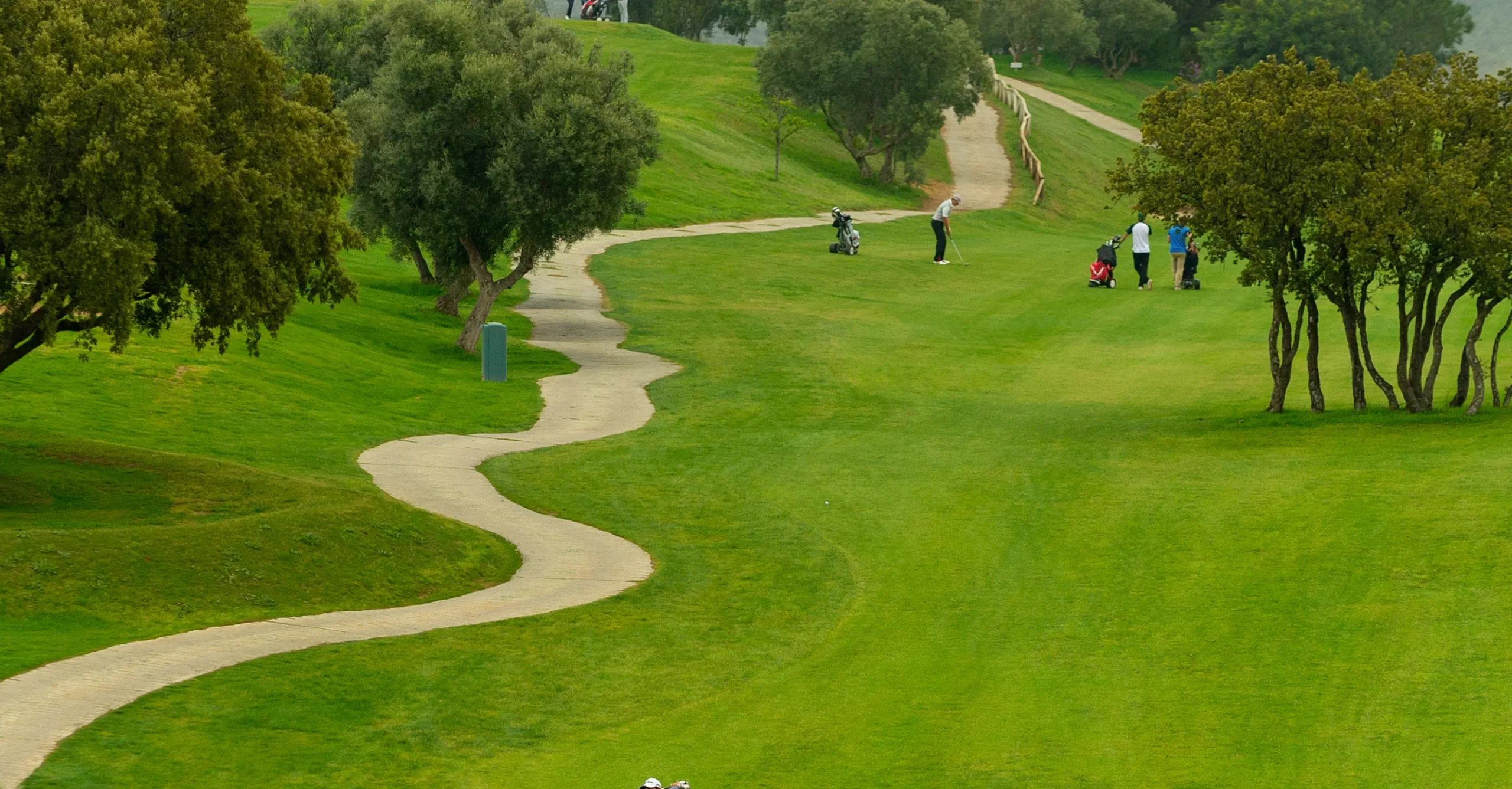 Weids uitzicht op de golfbaan van Golf Antequera met groene fairways en bergen op de achtergrond